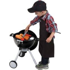 lapsi käyttämässä Weber Mini -lelugrilliä